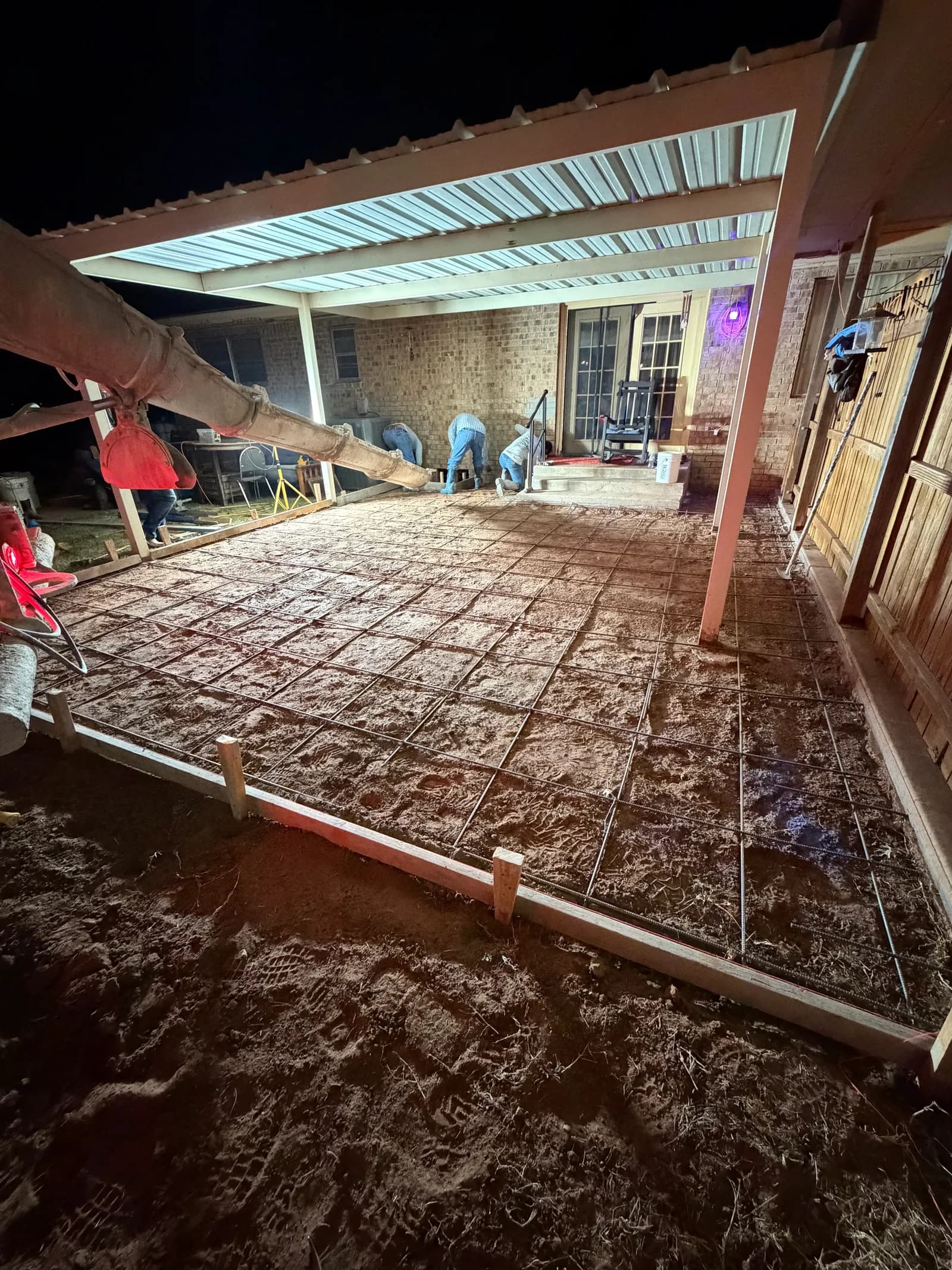 Crowell Backyard Concrete Patio — evening pour with forms and reinforcement under the covered porch in Crowell, TX